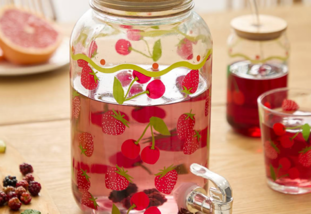 fontaine à boisson en verre avec robinet remplie de limonade aux fruits rouges fraises cerises