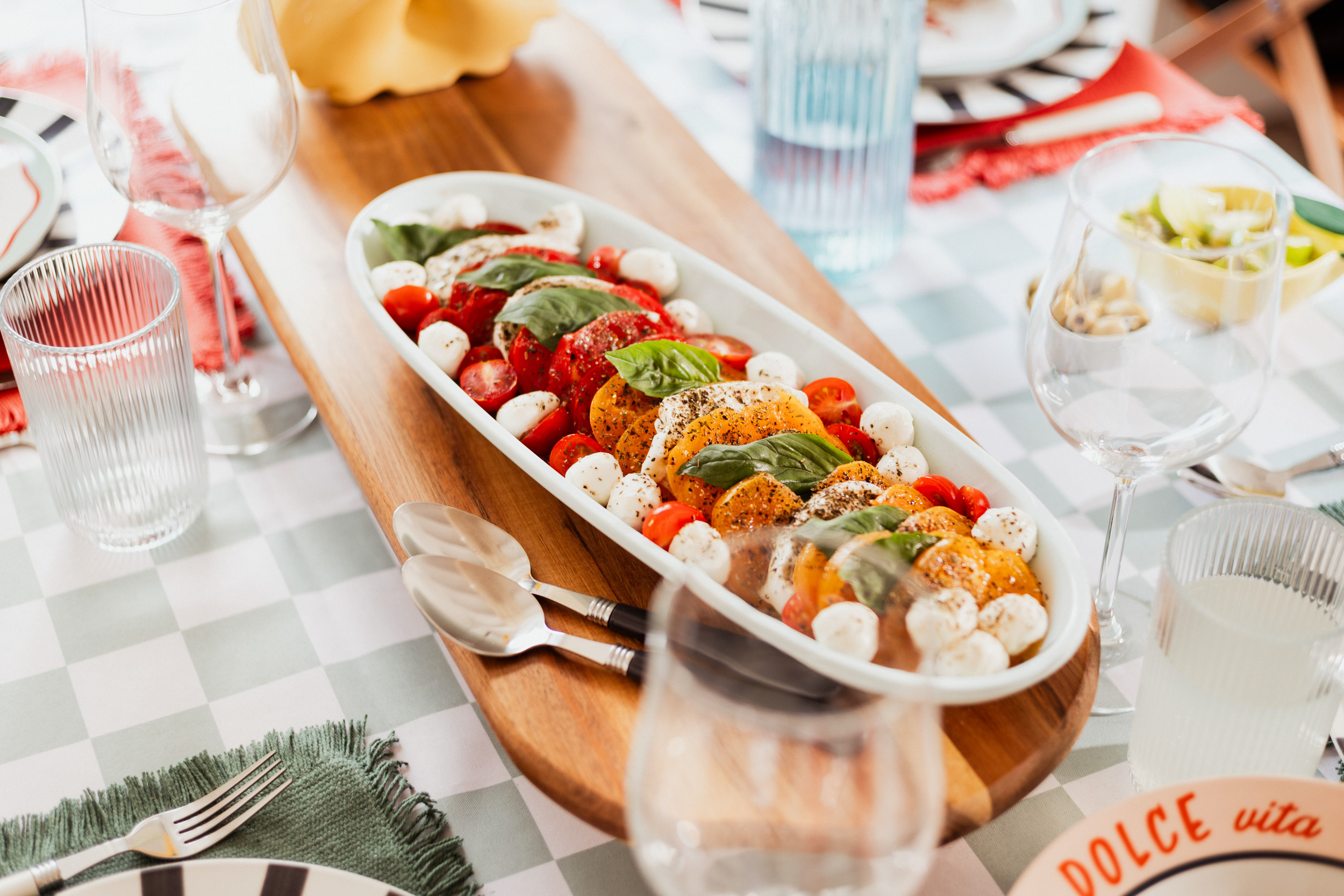 table guinguette avec nappe vichy verte plats à partager salade tomates mozzarella ambiance dolce vita