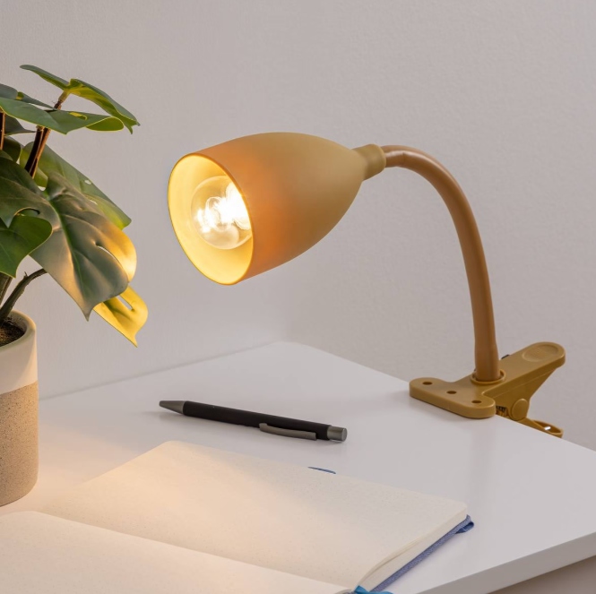 lampe de bureau jaune à pince orientable installée sur un bureau d'enfant pour les devoirs et les activités scolaires
