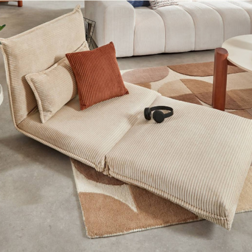 Chauffeuse convertible Atmosphera en tissu côtelé beige avec coussins décoratifs dans une chambre d'adolescent