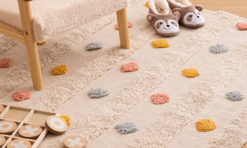 tapis enfant écru à pois tuftés colorés avec fauteuil en tissu bouclette, chaussons animaux et jouets en bois